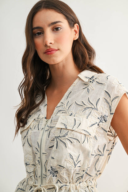 Woman wearing a floral dress against a plain background