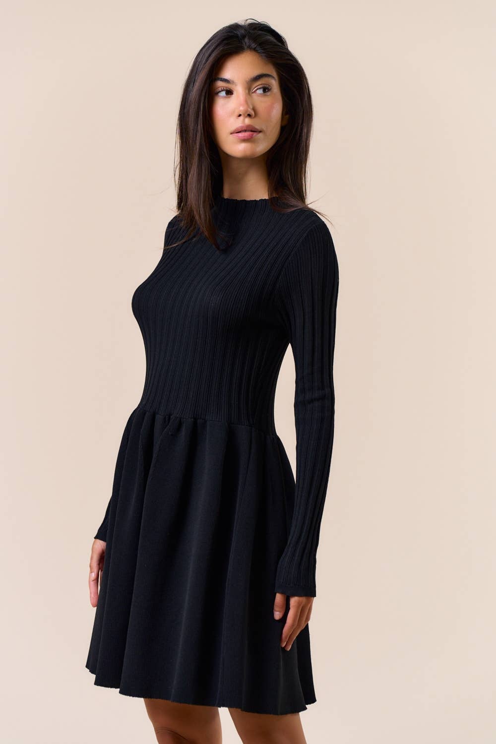 Woman wearing a black dress against a beige background