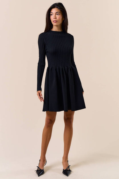 Woman wearing a black dress against a beige background