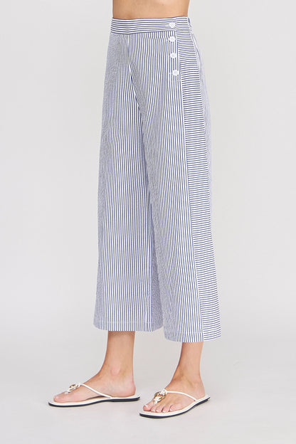 Person wearing blue and white striped pants on a plain background