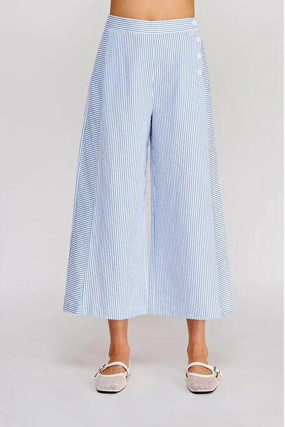 Blue and white striped wide-leg pants worn by a person on a light gray background