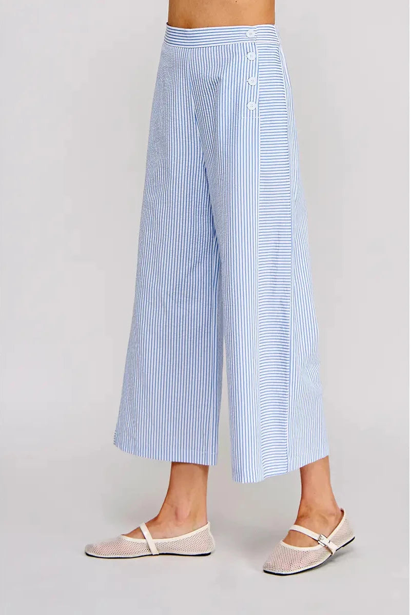 Light blue and white striped wide-leg pants worn by a person on a gray background