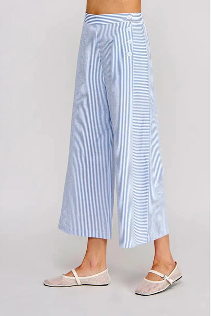 Light blue and white striped wide-leg pants worn by a person on a gray background