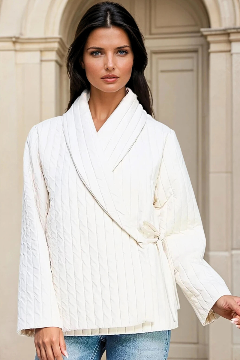 Woman wearing a white textured jacket with a neutral background
