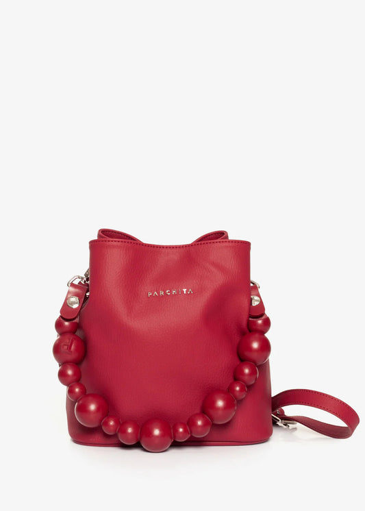 Red handbag with bead embellishments on a light gray background