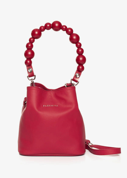 Red handbag with a unique handle design on a white background