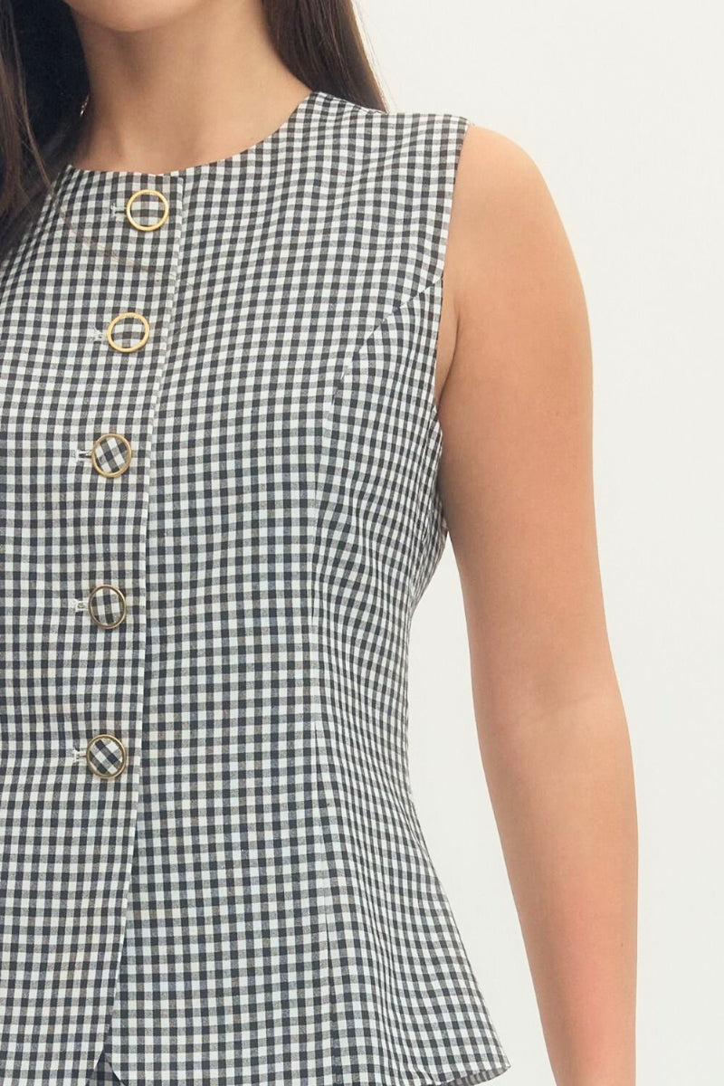 Black and white checkered sleeveless top with gold buttons on a plain background