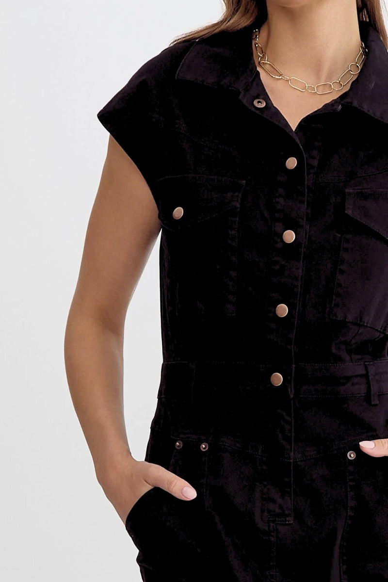 Black sleeveless jacket with button details on a plain background