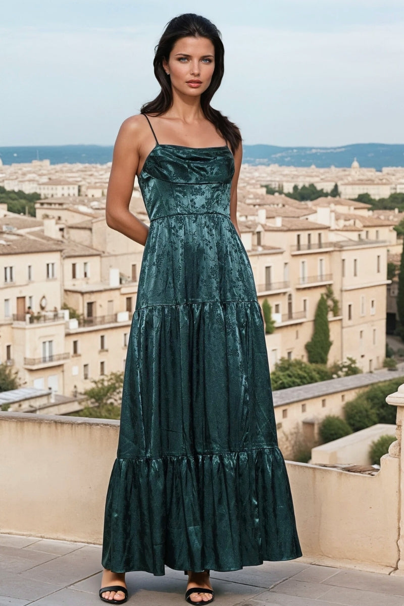Woman in a green dress standing on a rooftop with a cityscape in the background