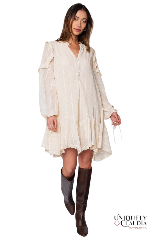 Woman wearing a beige dress with long sleeves and brown knee-high boots on a white background, with 'Uniquely Claudia' branding.