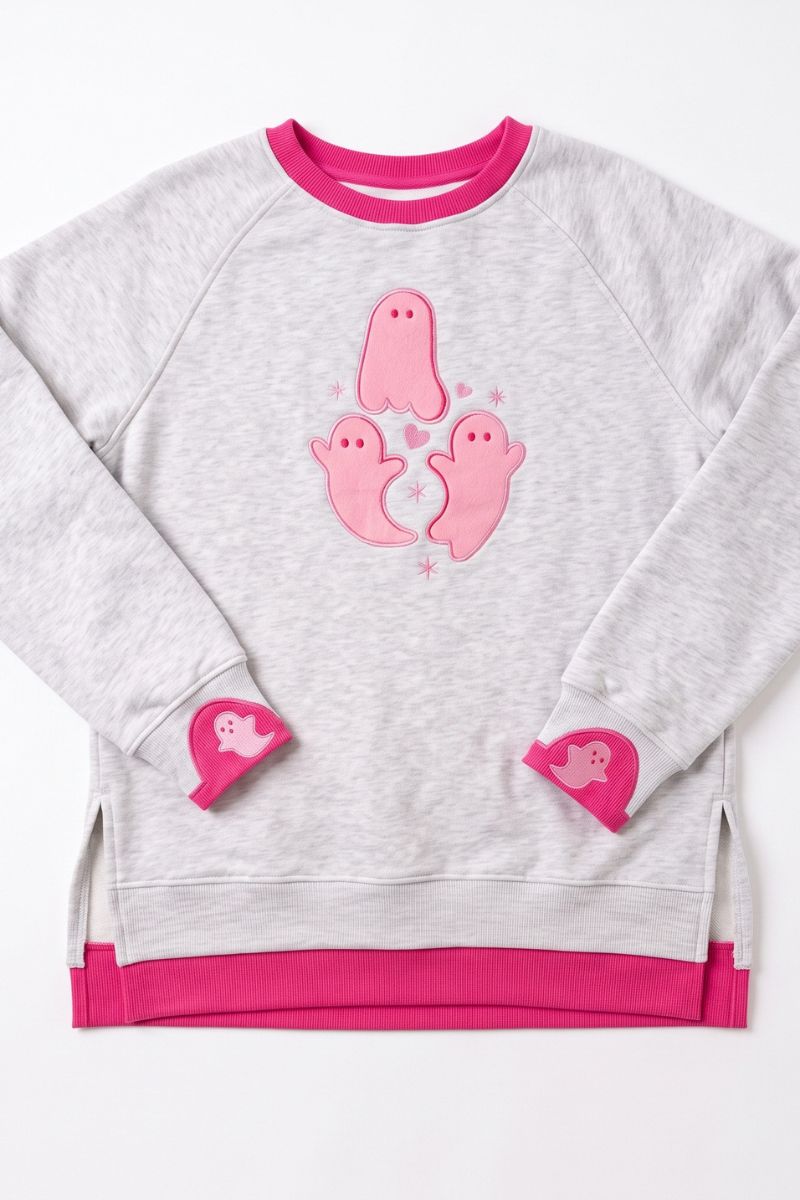 A light heather gray sweatshirt with vibrant pink accents, featuring three pink ghost appliqués on the chest and matching pink heart-shaped appliqués on the cuffs, displayed flat against a white background.