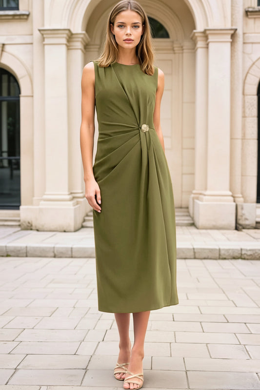 Woman wearing a green dress standing in front of classical architecture