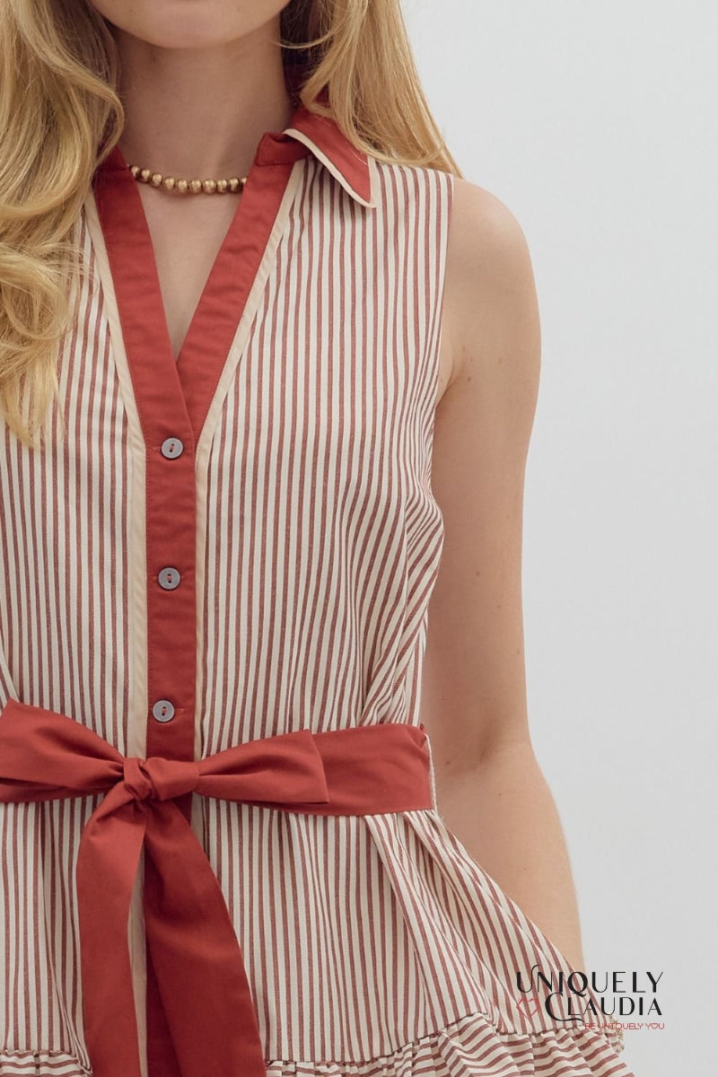 Woman wearing a striped dress with a red collar and belt on a white background