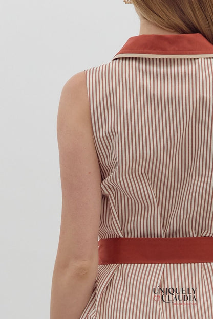 Striped dress with a red belt and collar on a plain background