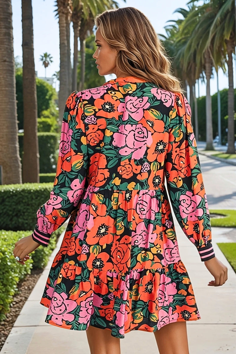 Woman wearing a colorful floral dress walking on a sidewalk with palm trees in the background