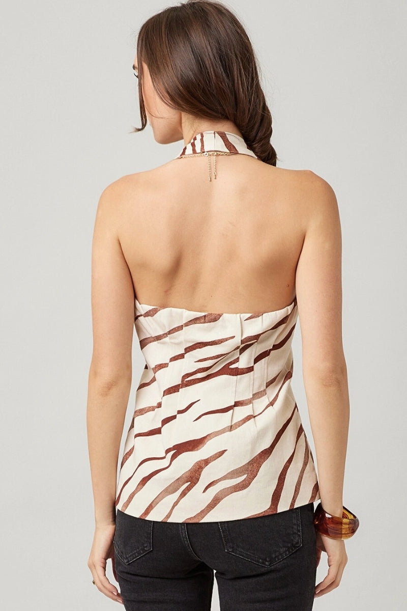 Woman wearing a strapless top with zebra pattern on a plain background