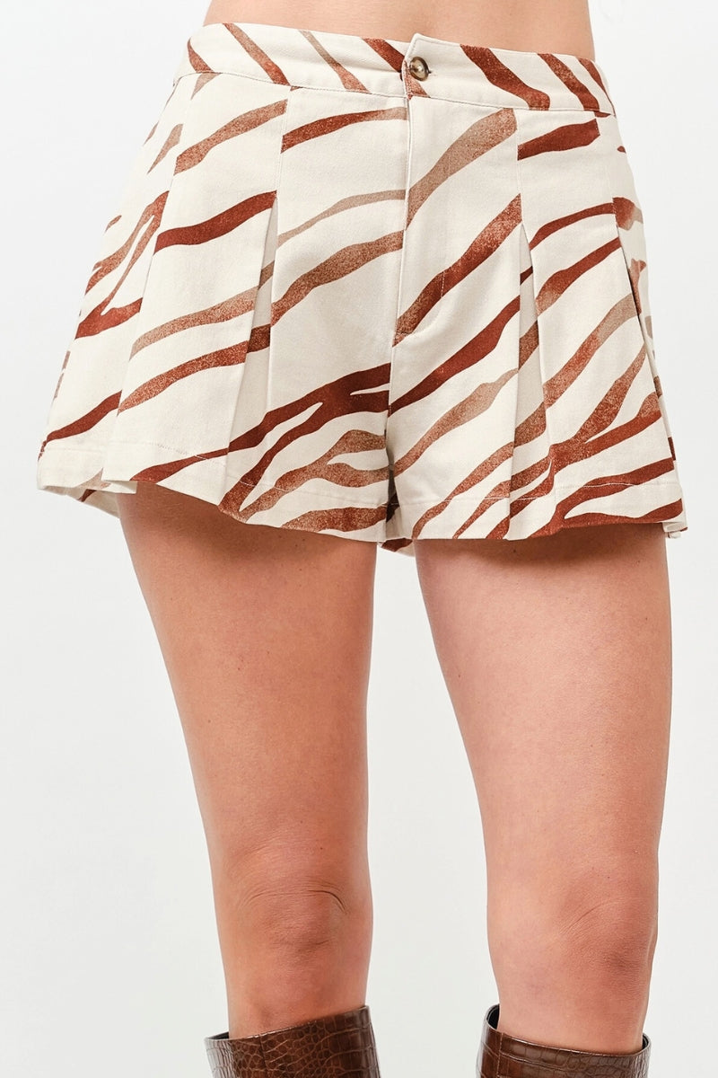 Zebra print shorts worn by a person on a plain background