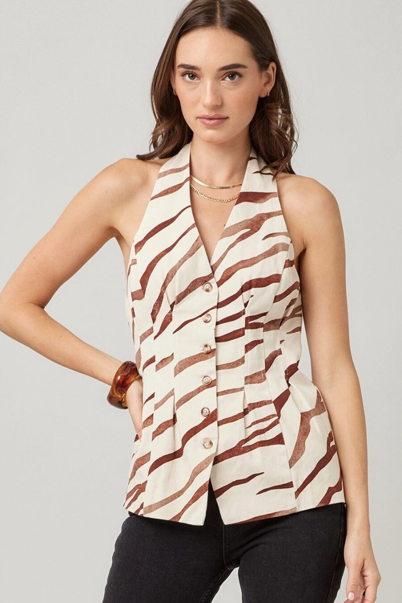 Woman wearing a sleeveless patterned top against a plain background