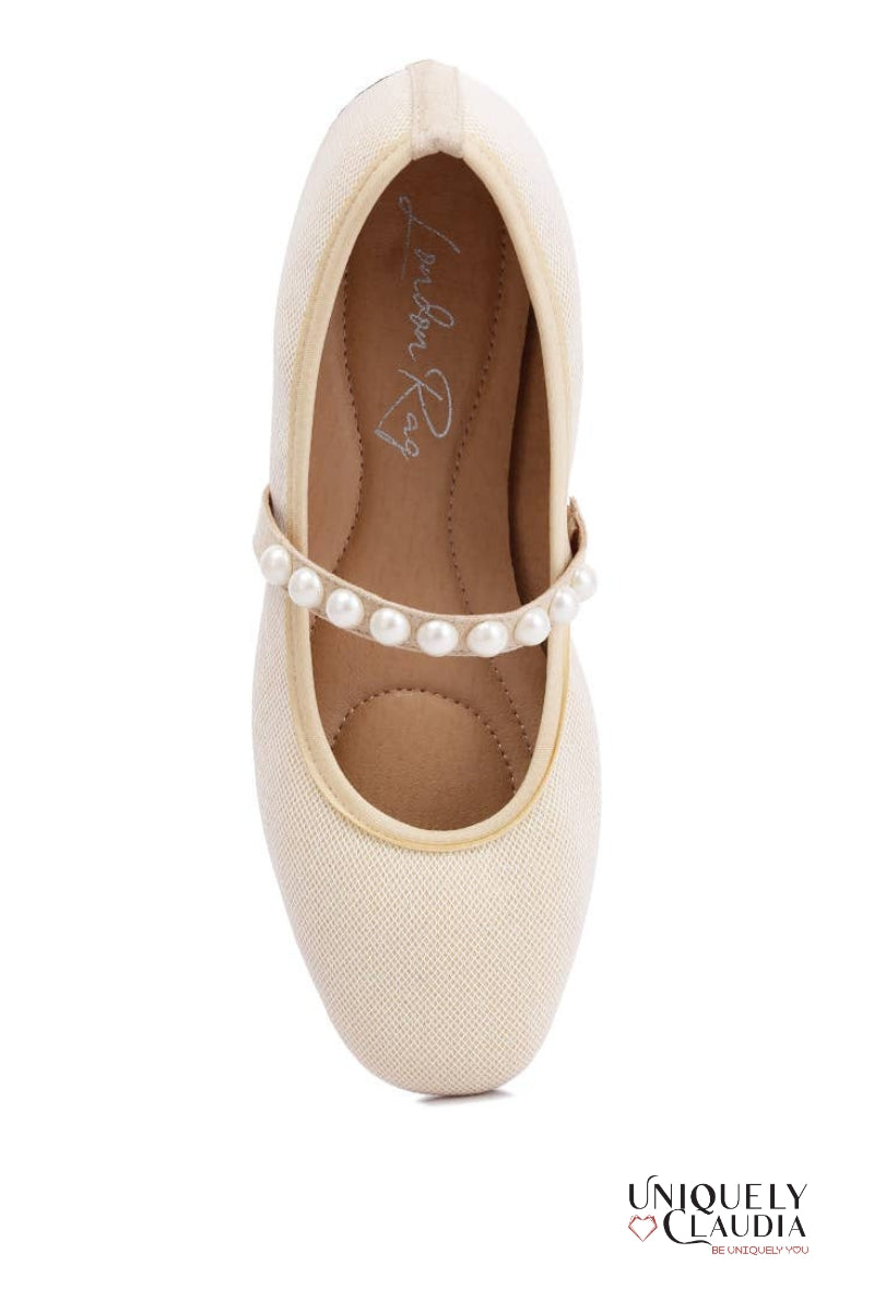 Beige ballet flat shoe with pearl embellishments on a white background