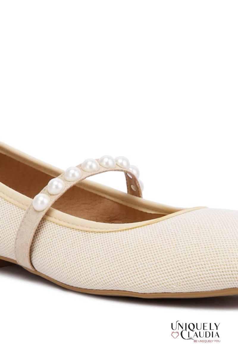 Beige flat shoe with pearl strap on a white background, featuring 'Uniquely Claudia' branding.