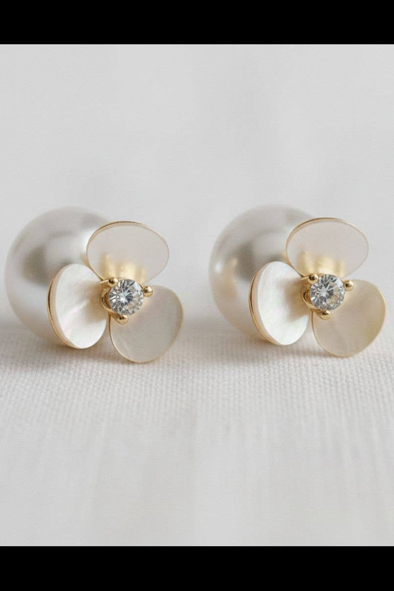 Pair of pearl earrings with gold accents on a light gray background