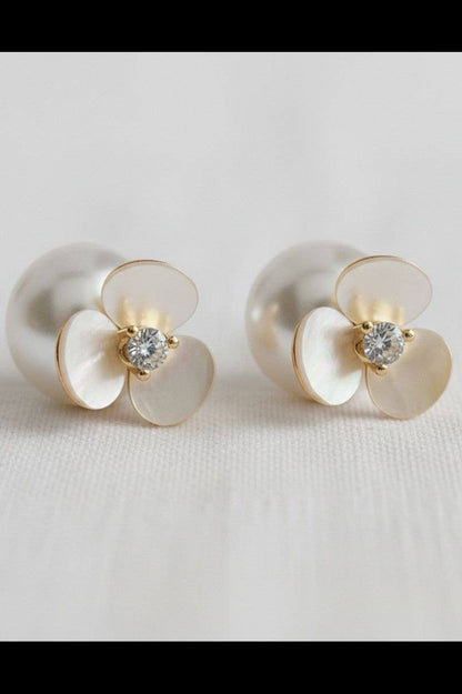 Pair of pearl earrings with gold accents on a light gray background