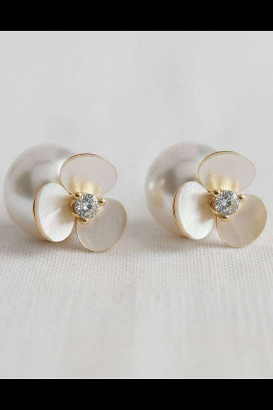 Pair of pearl earrings with gold accents on a light gray background