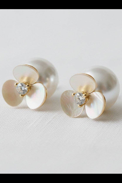 Pair of earrings with gold and pearl design on a light background