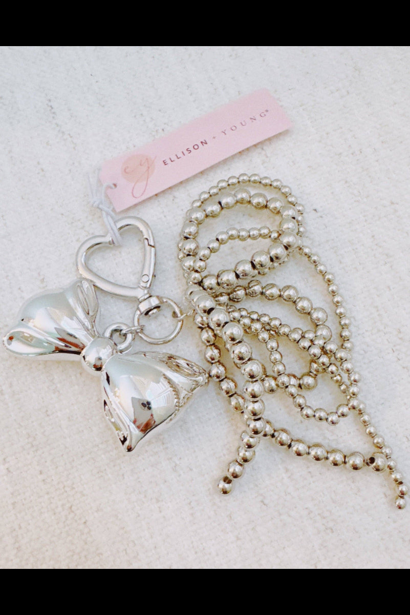 Silver keychain with heart and bow design on a string, branded 'Ellison & Chloe', on a light background.