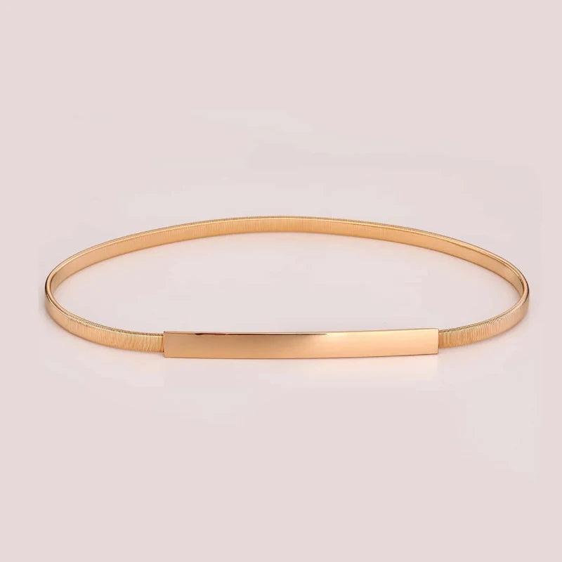 Gold bangle on a light pink background