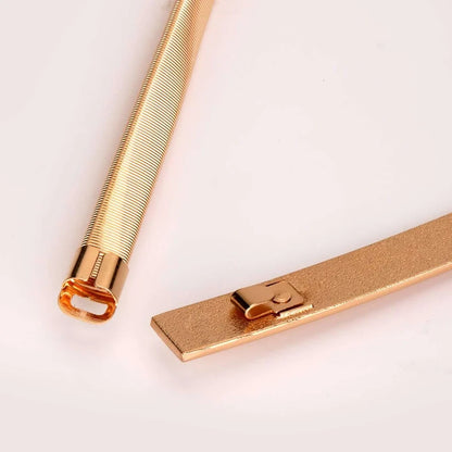Gold pen and clip on a light pink background