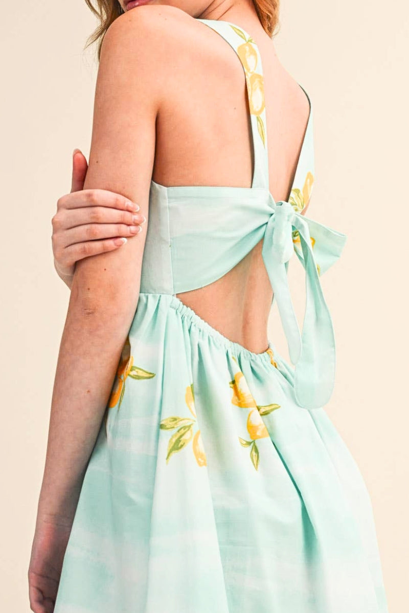 Light blue dress with yellow floral patterns on a beige background