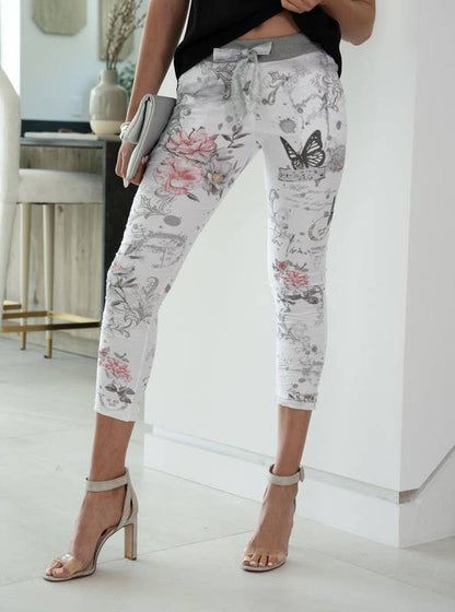 Person wearing floral-patterned pants in a minimal indoor setting