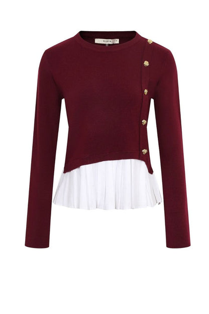 A long-sleeve knit top in deep burgundy with a white ruffled hem overlay and gold buttons on the front, shown on a plain white background.