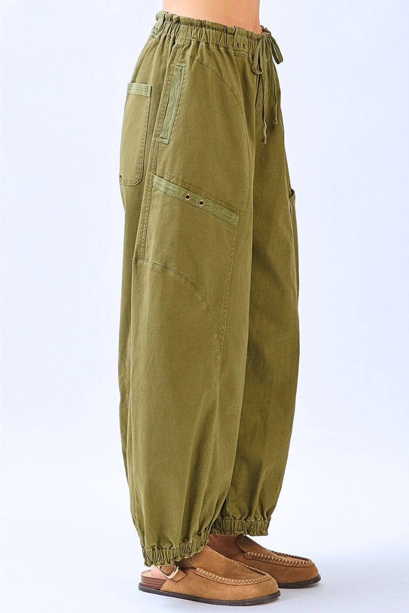 Green baggy pants worn by a person on a white background
