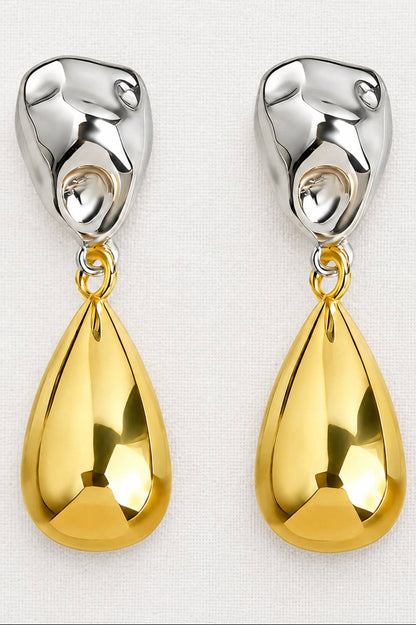 A pair of dangling earrings with polished silver-tone abstract top pieces and large teardrop-shaped gold pendants, shown on a light textured background.