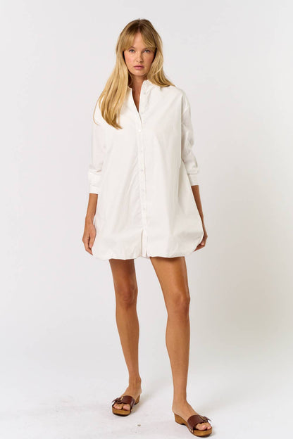 Woman wearing a white shirt dress on a white background