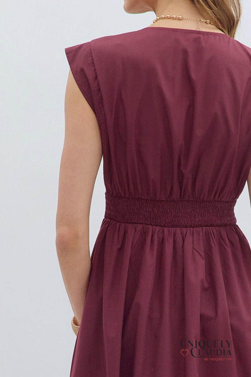Maroon dress worn by a person on a light gray background