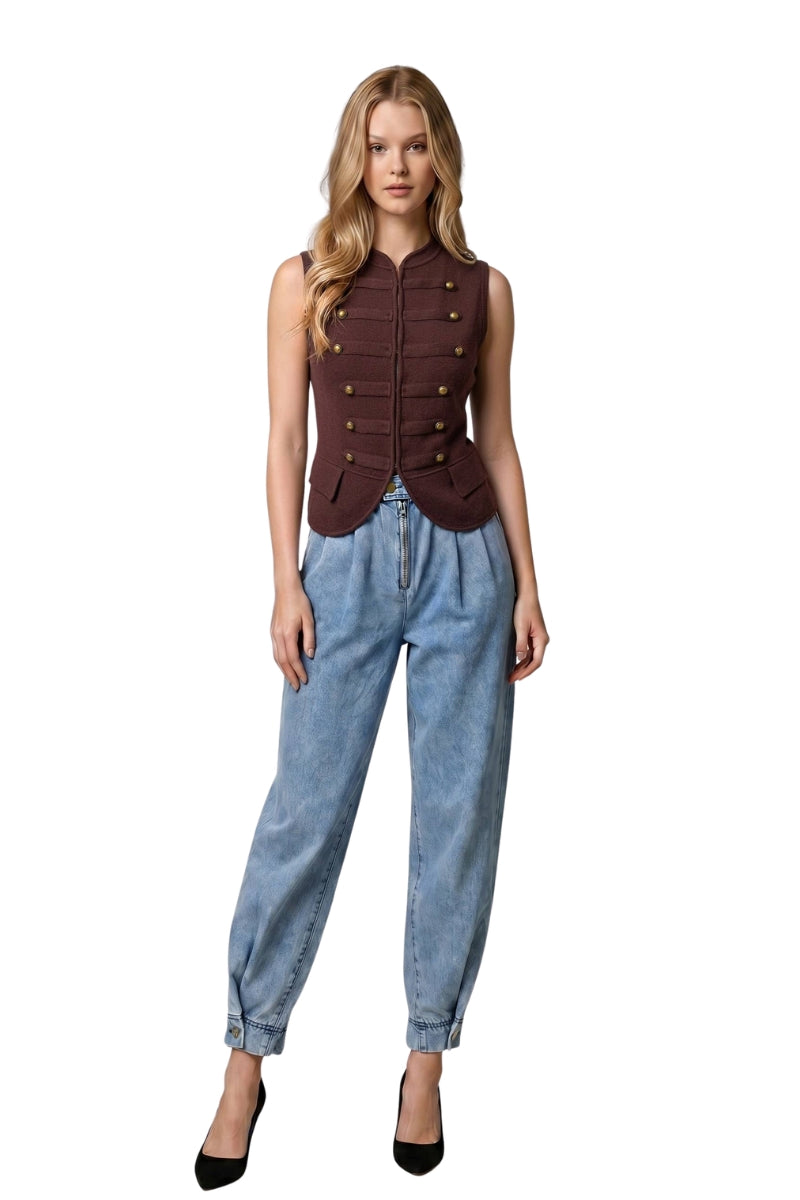 A woman modeling a sleeveless dark brown military-style vest with gold buttons, paired with light-wash blue jeans and black heels, against a plain white background.
