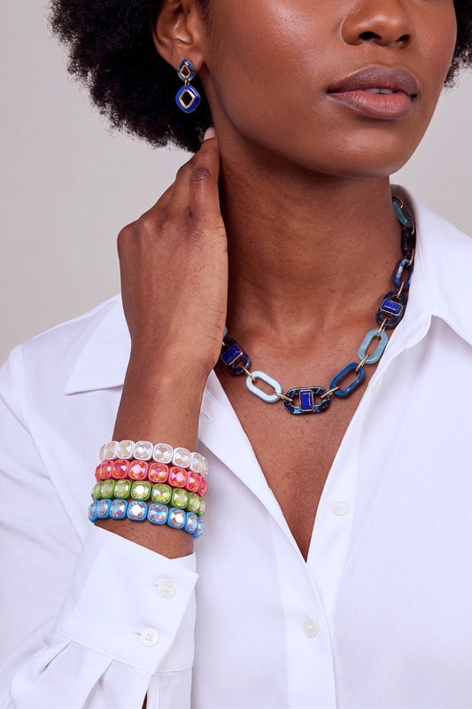 Woman wearing a colorful necklace and bracelets on a plain background